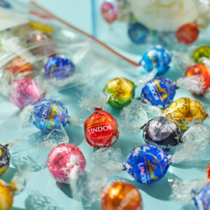 大好評企画!リンツのチョコレートをたっぷり詰めて楽しめる!「PICK&MIX詰め放題」を4月10日より期間限定で開催!〜推しカラーで楽しむ、6色の専用ポーチが新登場〜